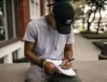 Man sitting and writing in a notebook.
